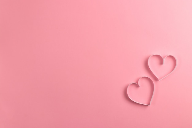 Photo composition for valentine's day february  .  delicate pink background and pink hearts cut out of paper.