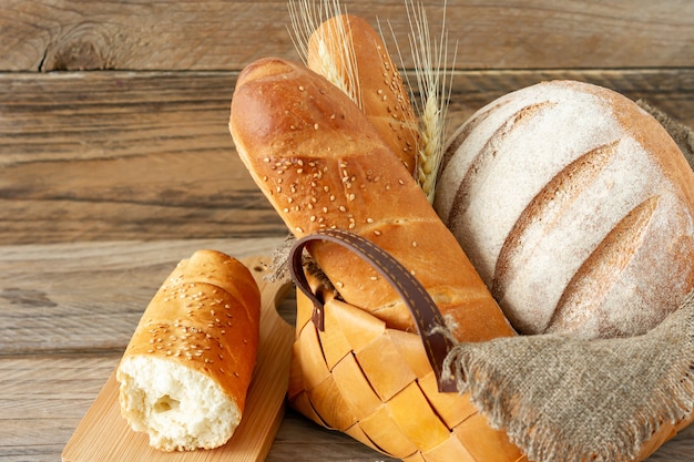 Composition of various baked products in basket on rustic background. Homemade fresh pastry.