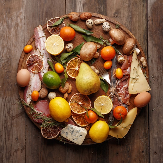 Composition of various foodstuffs on a wooden table. Top view.