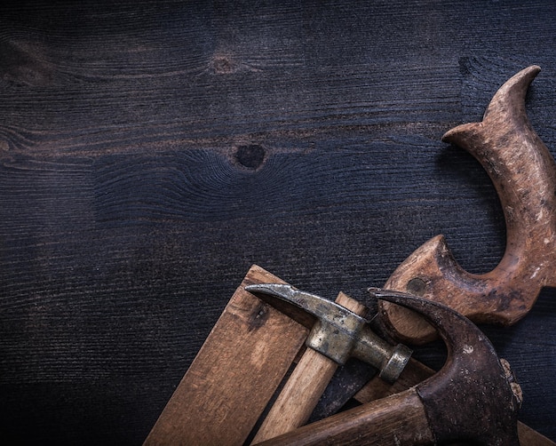 Composition of vintage square ruler rusted claw hammers hand saw