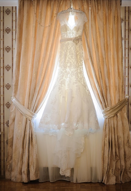 Composition wedding dress hanging at a wall