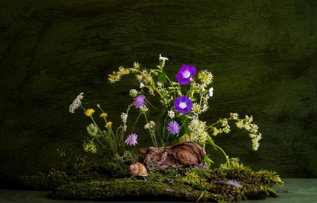 Composition of wildflowers moss tree roots Bouquet Ikebana