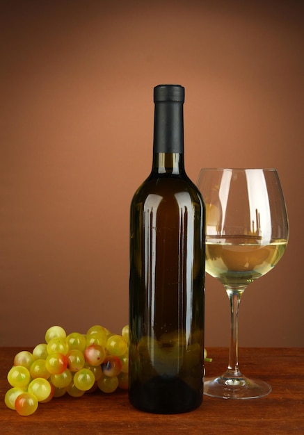 Composition of wine bottle glass of white wine grape on color background