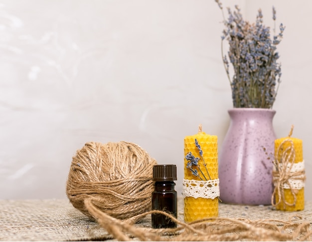 Composizione con accessori per realizzare candele di cera con le proprie mani e un vaso con fiori di lavanda