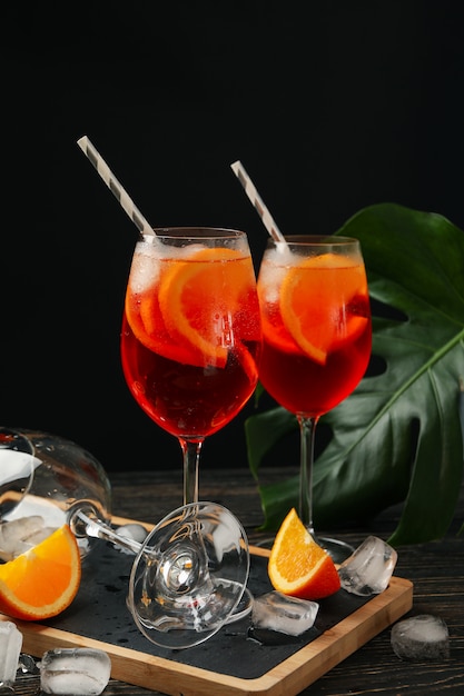 Composition with aperol spritz cocktail against black background