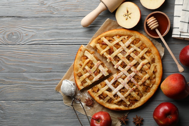 Composition with apple pie and ingredients on wooden background. Homemade food