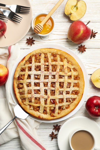 Composition with apple pie and ingredients on wooden background, top view