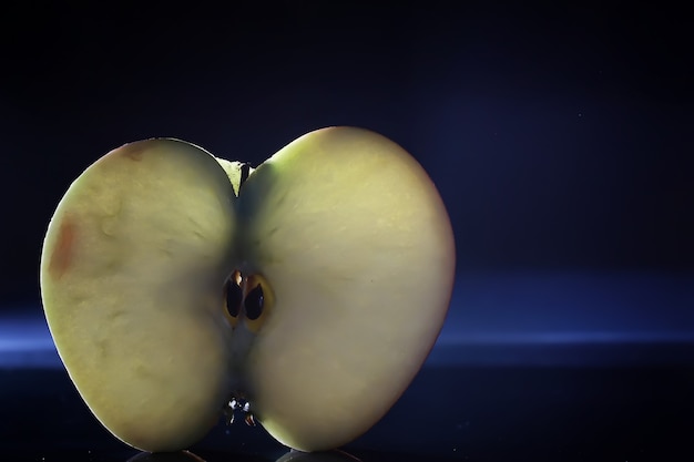 Composition with apple slices on a black backgroundJuicy apple on a table