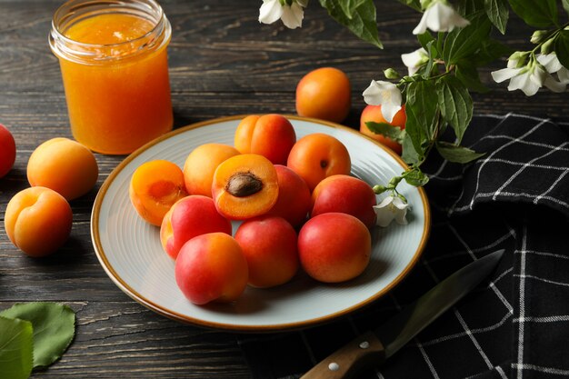 Composition with apricots and jam on wooden background