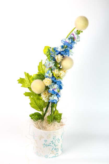 Composition with artificial violets in a pot on white background