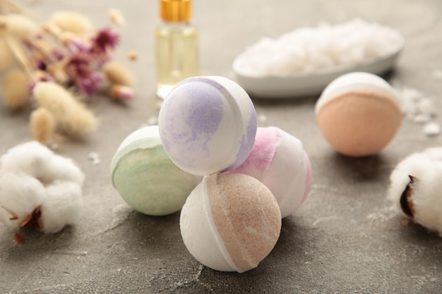 Photo composition with bath bombs, sea salt, dry flowers on grey background.