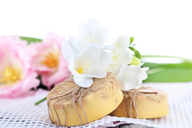 Composition with beautiful  flowers and soap on wooden background