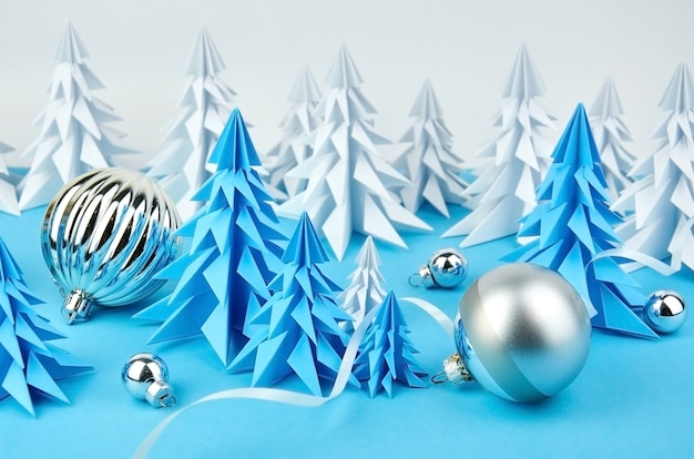 Composition with blue and white paper Christmas trees and ball decorations