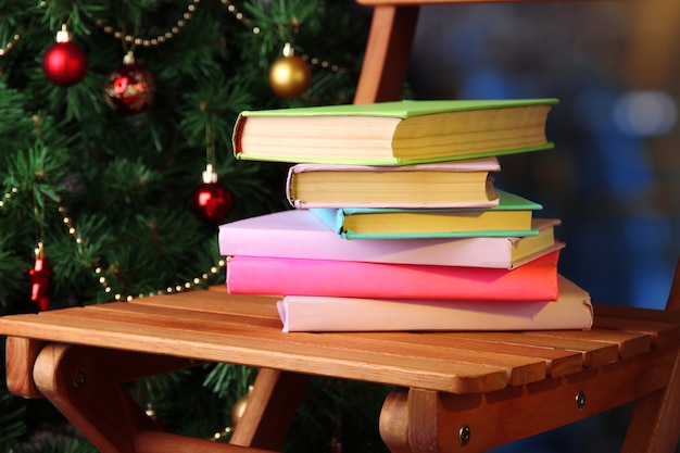 Foto composizione con libri sulla sedia sullo sfondo dell'albero di natale