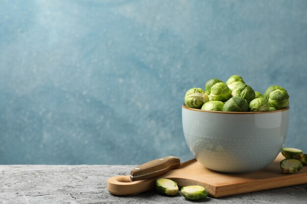 Composition with bowl of brussels sprout on grey table