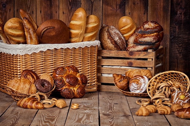 Композиция с хлебом и булочками в плетеной корзине.