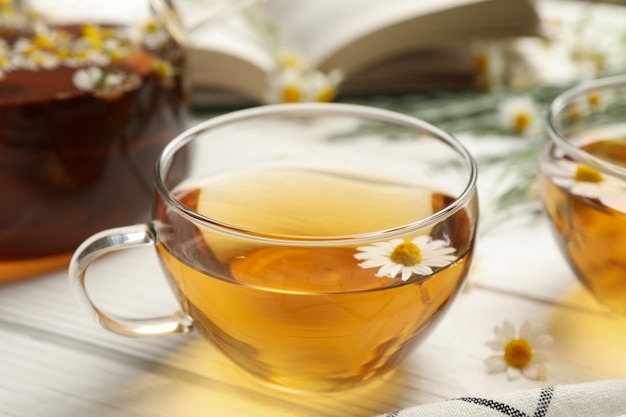 Composition with chamomile tea on white wooden background