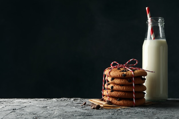 Composition with chip cookies and milk on gray table