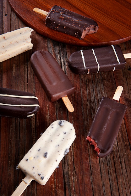 Composition with chocolate popsicles on wooden background. Top view