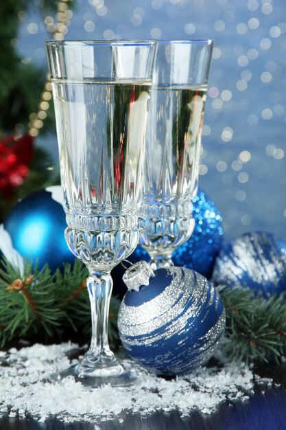 Composizione con decorazioni natalizie e due bicchieri di champagne, su sfondo luminoso