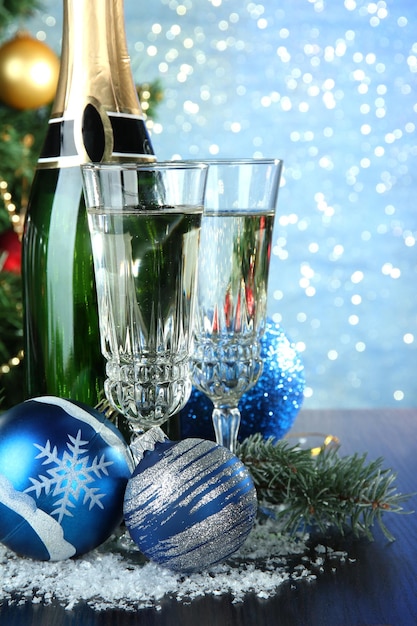 Composition with Christmas decorations and two champagne glasses, on bright background