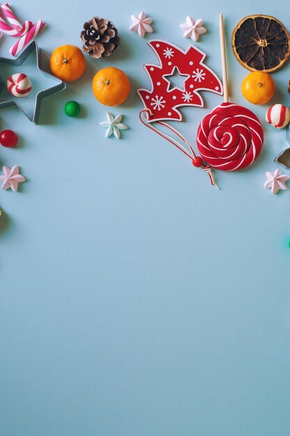 写真 クリスマス オブジェクト キャンディー杖モミの枝と明るい青の背景にみかんのコンポジション トップ ビュー コピー テキストのスペース
