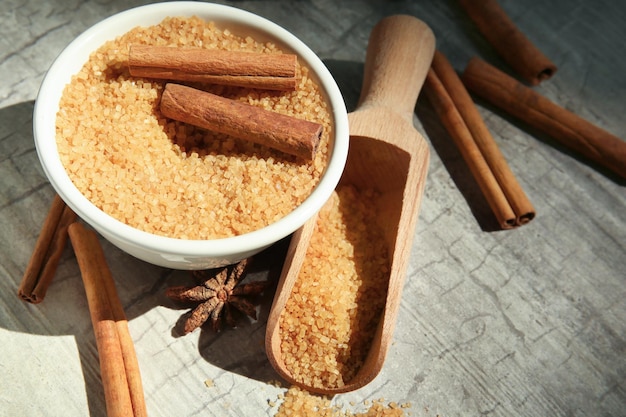 Foto composizione con zucchero alla cannella e bastoncini su fondo di legno