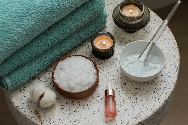 Composition with cosmetic alginate facial mask for spa treatments aroma oil epsom or magnium salt candles and terry towels on a terazzo table