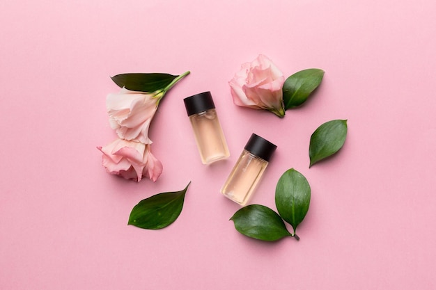 Composition with cosmetic products and beautiful roses on color background. Flat lay