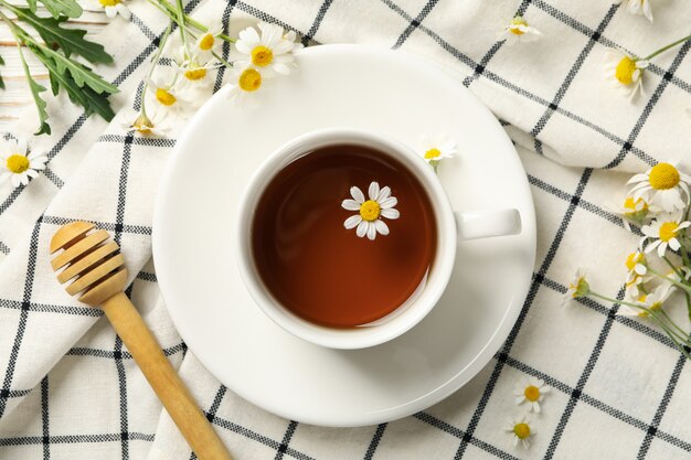 Composition with cup of chamomile tea on white wooden background