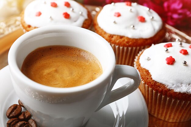 Foto composizione con tazza di caffè muffin e fiori di peonia sul vassoio su fondo di legno