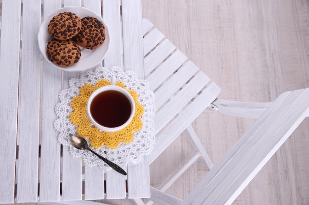 Composition with cup of hot drink and cookies on wooden table background