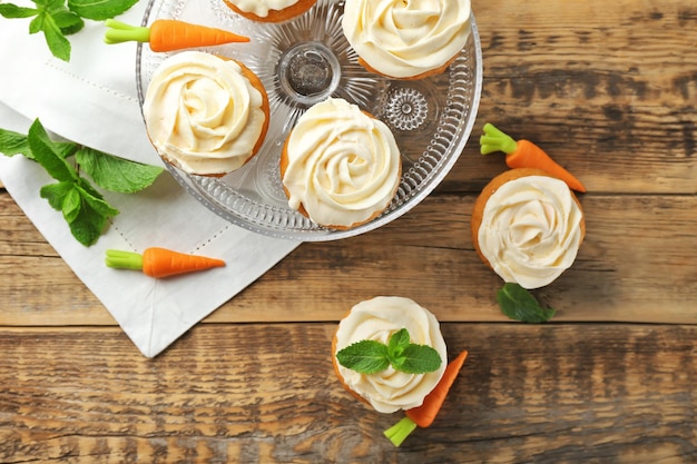 Composition with delicious carrot muffins on wooden table