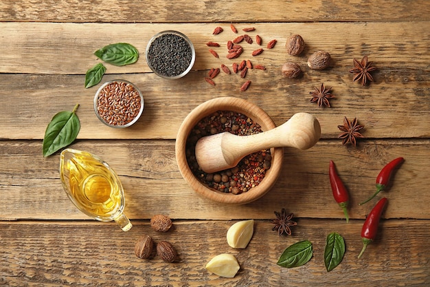 Composition with different spices and mortar on wooden background