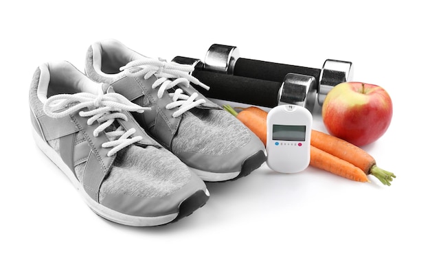 Composition with digital glucometer and sport inventory on white background Diabetes concept