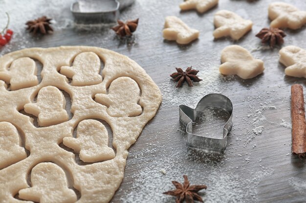 Composition with dough for Christmas cookies on wooden table