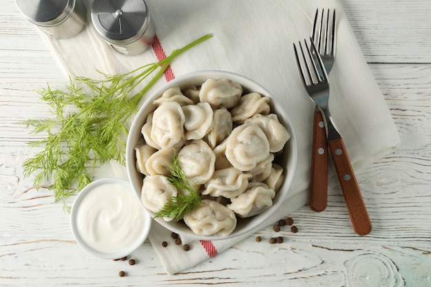 Composition with dumplings, towel and spices on wooden background, top view