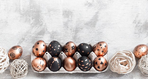 Composition with Easter eggs painted in gold and black colors with ornaments
