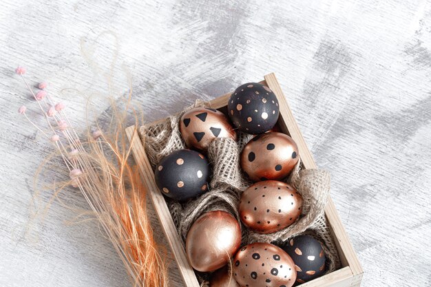 Composition with Easter eggs painted in gold and black on light.