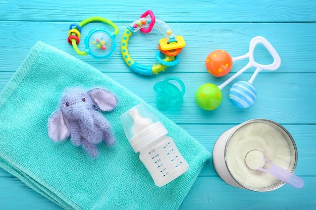 Composition with feeding bottle of baby milk formula on wooden table