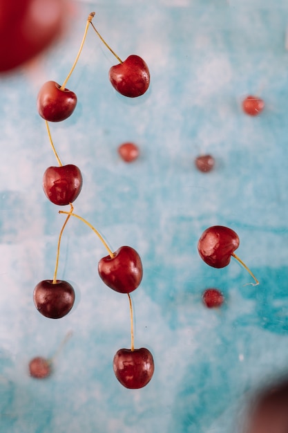 Composition with Flying sweet red berries about levitation on blue background . Levitating Food, Levitating Berries
