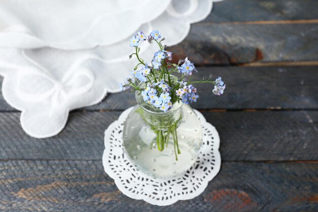 Composition with Forget-me-nots flowers on wooden background