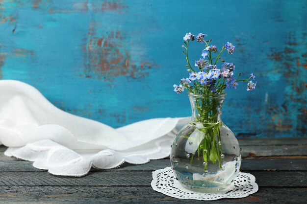 Composition with forget-me-nots flowers on wooden background