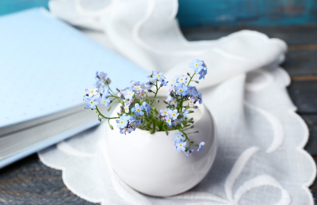 Composition with Forget-me-nots flowers on wooden surface