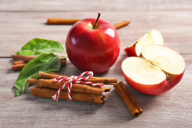 Composition with fresh apples and cinnamon sticks on wooden table