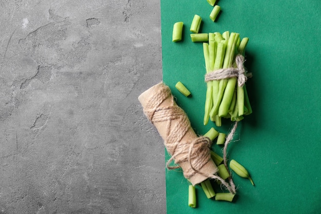 Composition with fresh green beans and thread on table