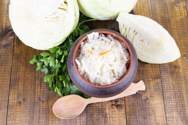 Composition with fresh and marinated cabbage sauerkraut spices on wooden table background