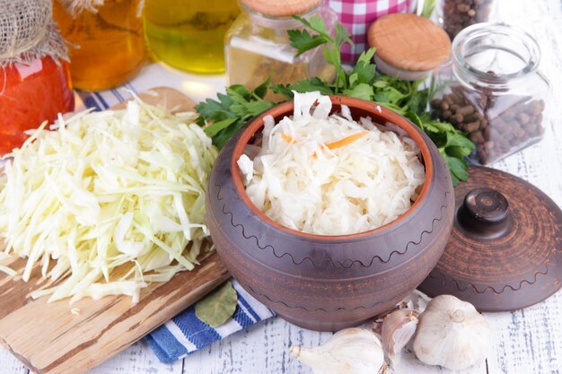 Composition with fresh and marinated cabbage sauerkraut spices on wooden table background