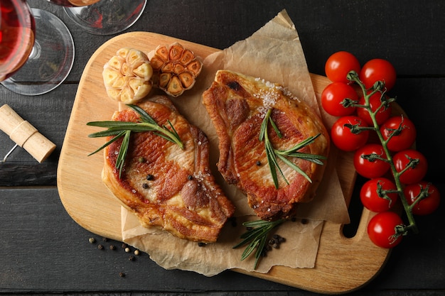 Composition with fried steaks on wooden table. Grilled food