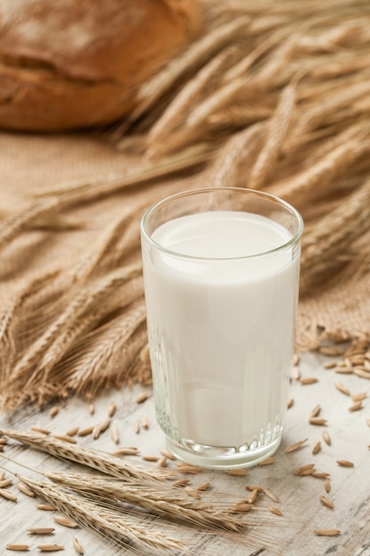 Composition with glass of milk, bread and ears of rye on sacking.